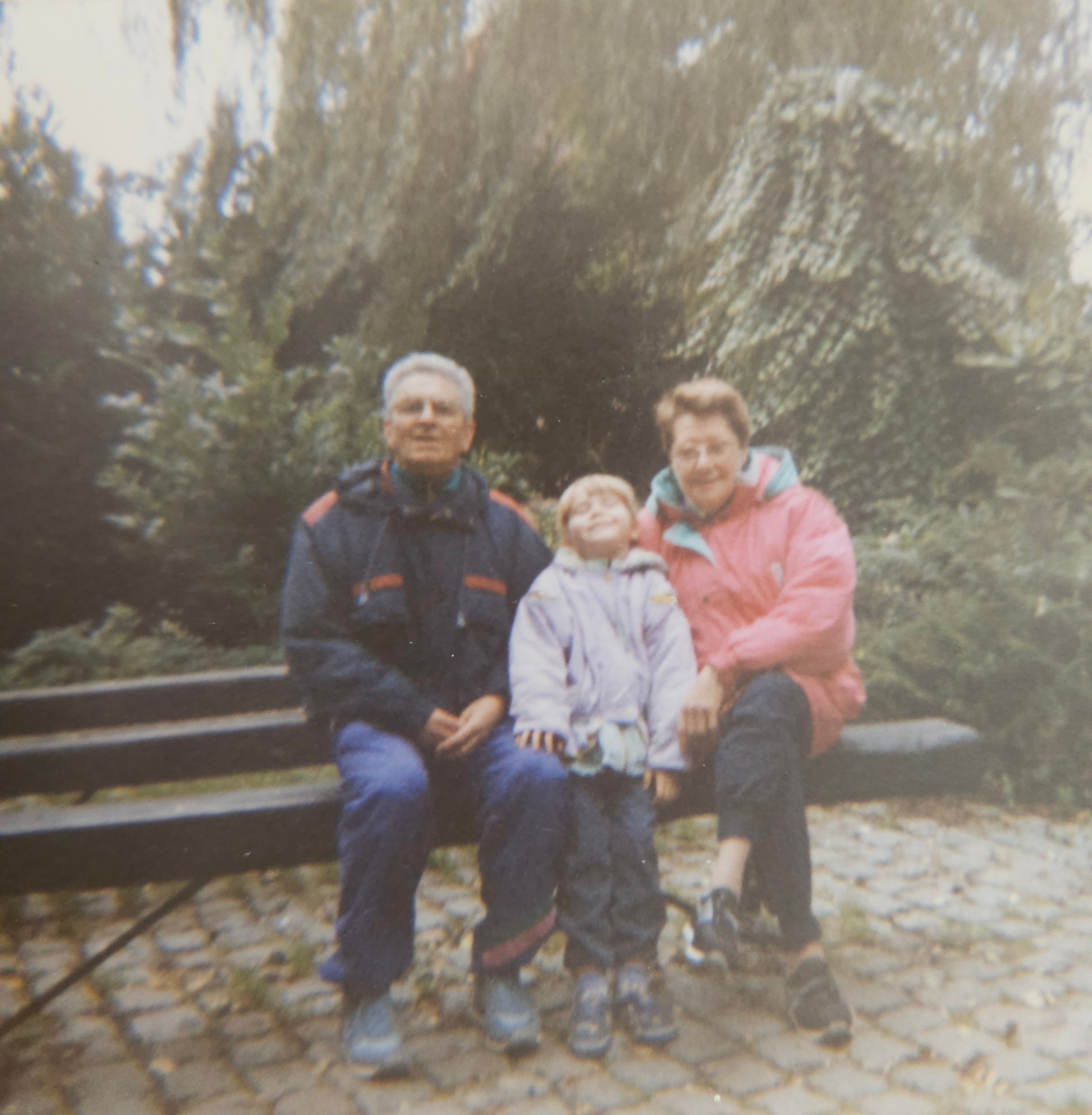 Grootouders met kleinkind op een bank in het park